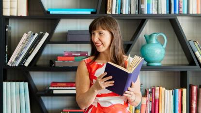 Woman in front of a bookshelf trying to read more books