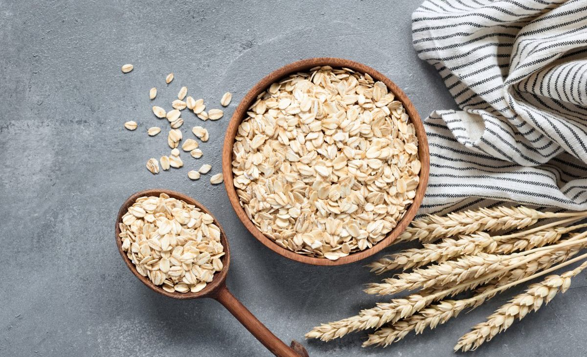Oats, rolled oats or oat flakes in wooden bowl