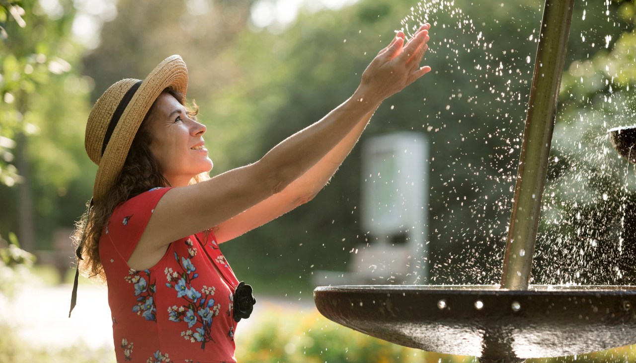 woman splashing in fountain