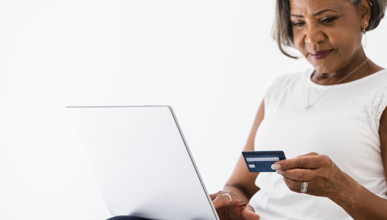 Mature business woman carefully checks numbers on credit card