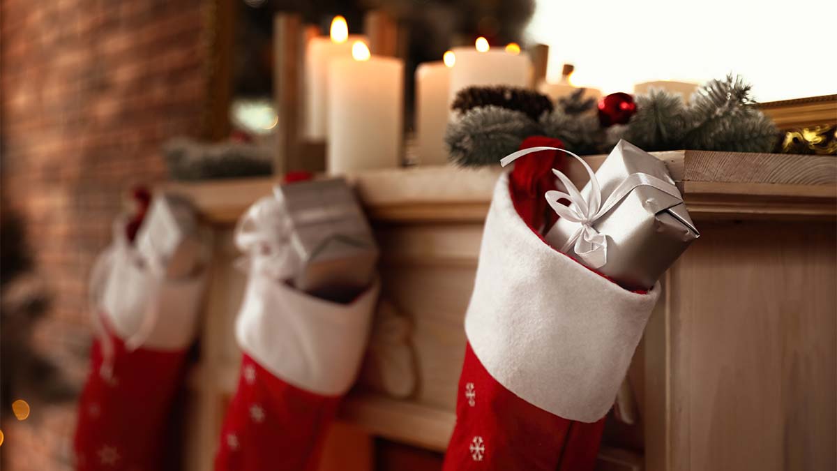 https://www.womansworld.com/wp-content/uploads/2022/12/Decorative-fireplace-with-Christmas-stocking-and-gifts.jpg