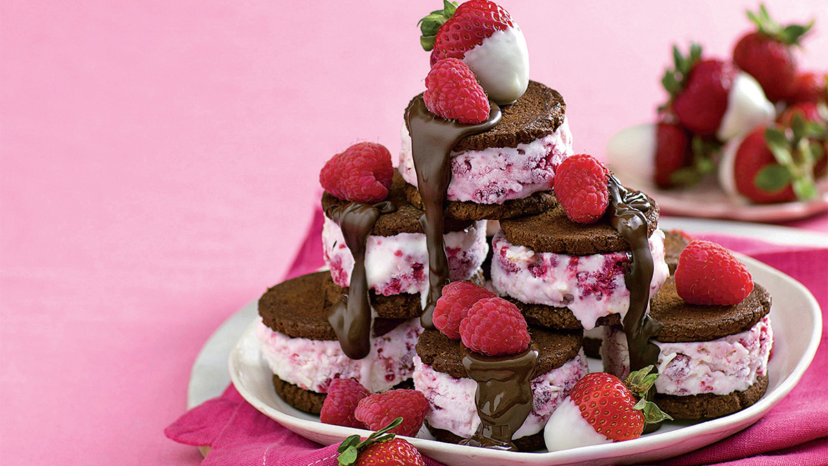 Berry ice cream sandwiches topped with more berries and chocolate sauce