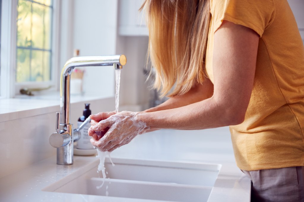 mature woman washing hands to help with thyroid and hair loss