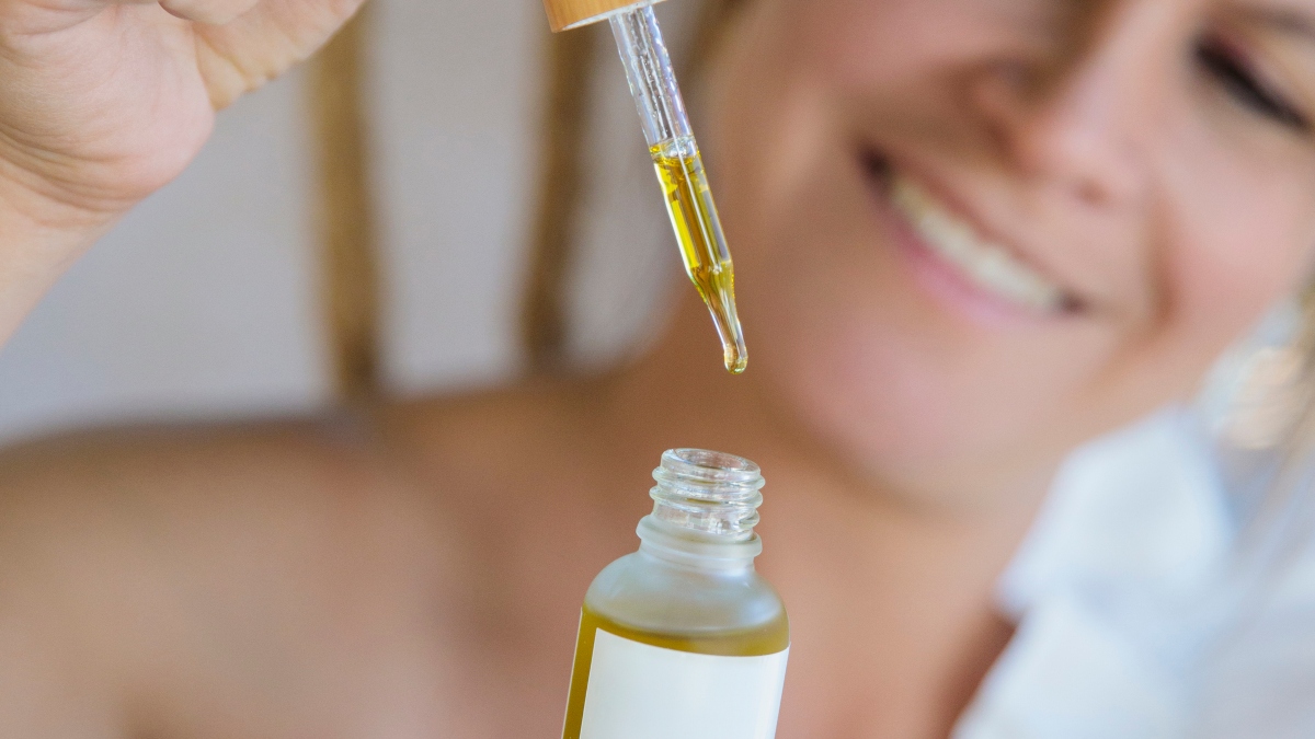 Mature woman holding oil serum for oilplaning