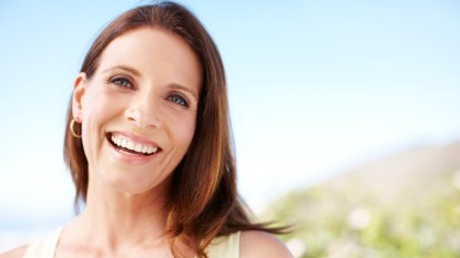 mature woman smiling outside in the summer
