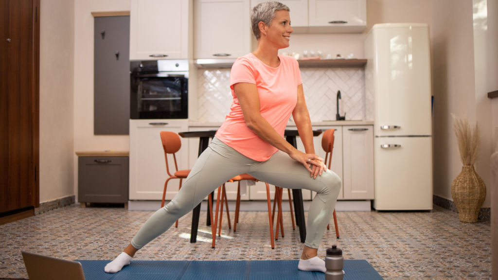 Older woman stretching on an exercise mat indoors