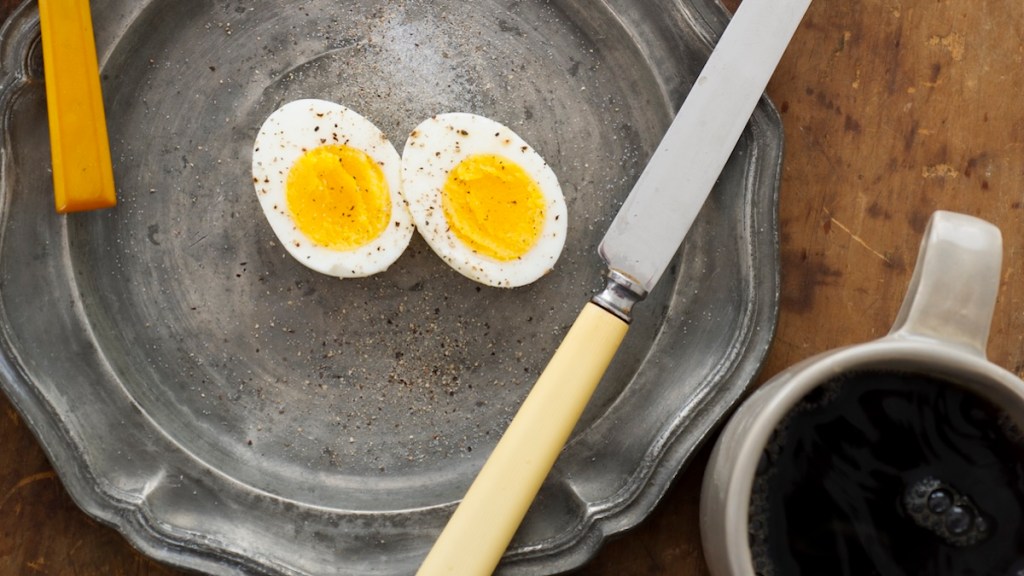 eggs on plate next to black coffee