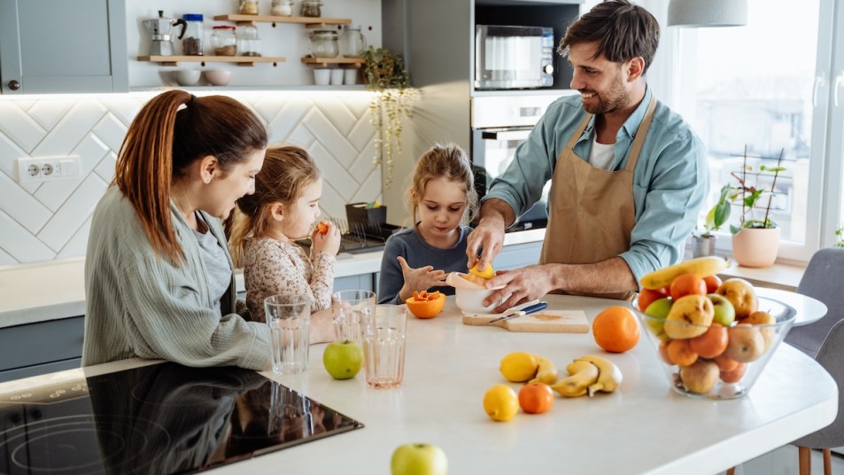 Man prepares fresh fruit in the kitchen for his family