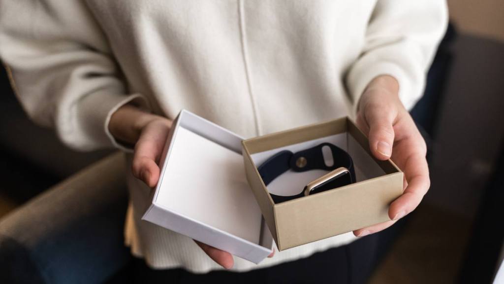 father's day gifts: Close up of hands with open gift box with smart watch