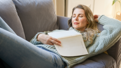 Woman napping on couch with her book, practince the dolce far niente lifestyle