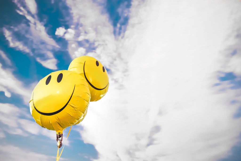 Friendly smiley face balloons flying in the sky to promote optimism joyce meyer joy of an uncluttered life
