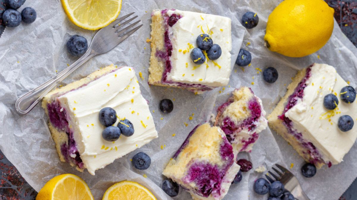 Blueberry and lemon Jello poke cake pieces with whipped topping and fresh fruit
