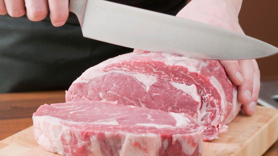 Person slices beef with chef knife