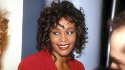 young woman smiling; whitney houston young