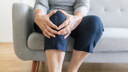 Older woman holding her knee in pain, trying to heal a torn meniscus naturally