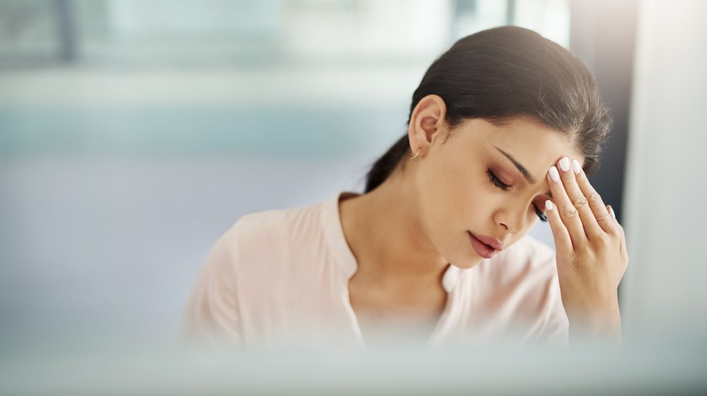 Young woman holding her head in pain