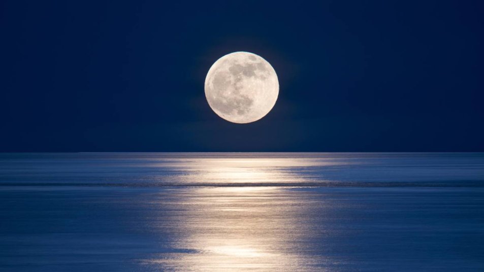 Seattle, San Juan islands giant moonrise over Salish sea.