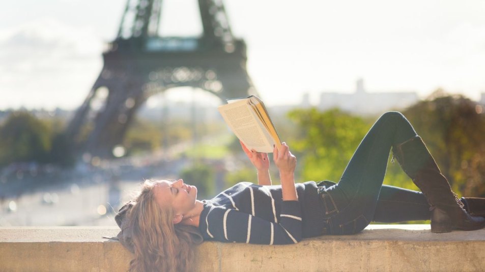 Girl reading a book in Paris on a sunny day