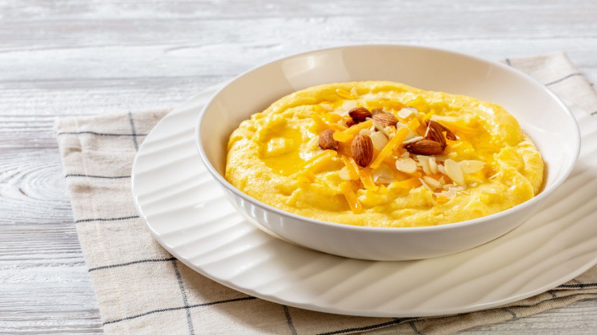 cheese grits with cheddar and almonds in white bowl