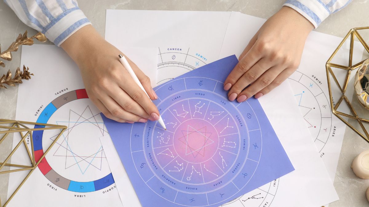 Astrologer using zodiac wheel for fate forecast at table, top view. Fortune telling