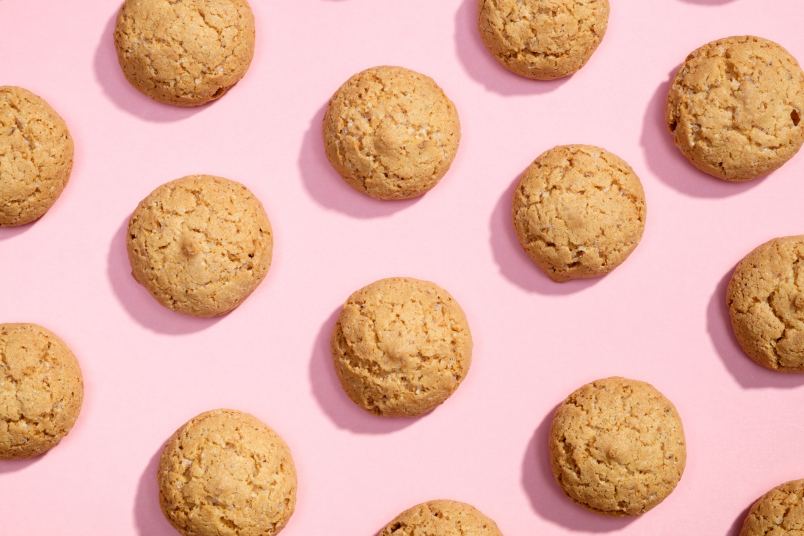 pattern of homemade crumbl cookies against pink background