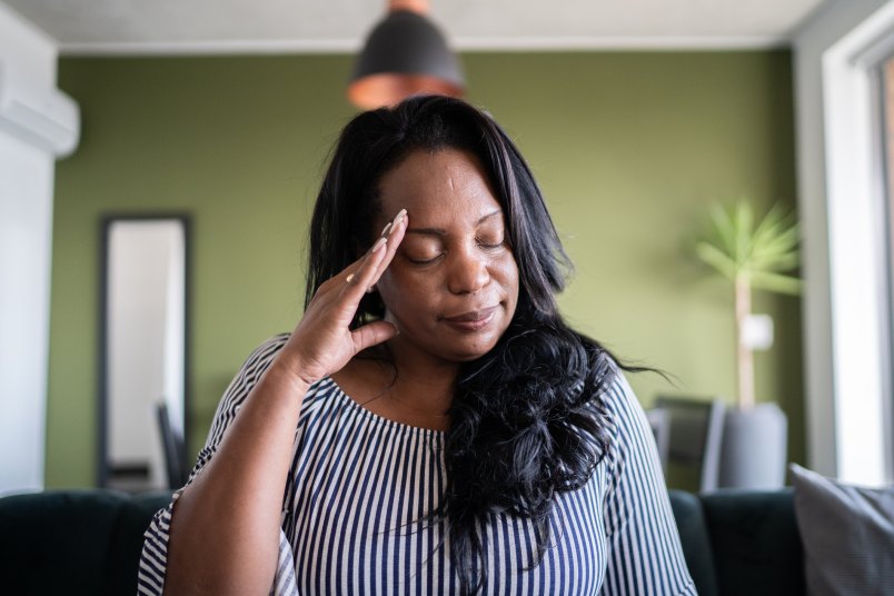 mature woman with her hand to her head trying to figure out which ear is causing vertigo