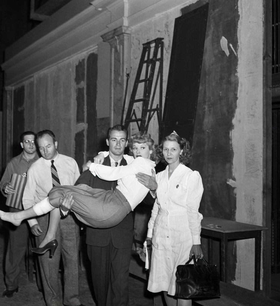 A shot that was not in the script is this one of Lucille Ball being carried off the set of ‘Dark Corner,' by her co-star Mark Stevens. The bandage on Lucille's left leg covers a blood vessel broken when she tripped and fell from a raised platform on the stage. A studio nurse and two assistant directors were ready to assist.