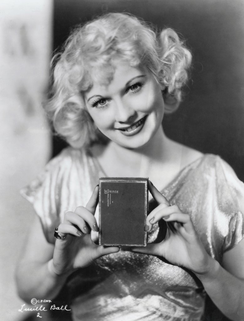 Lucille Ball, at age 22, displaying perfume. Before her success as an actress, she was a model.