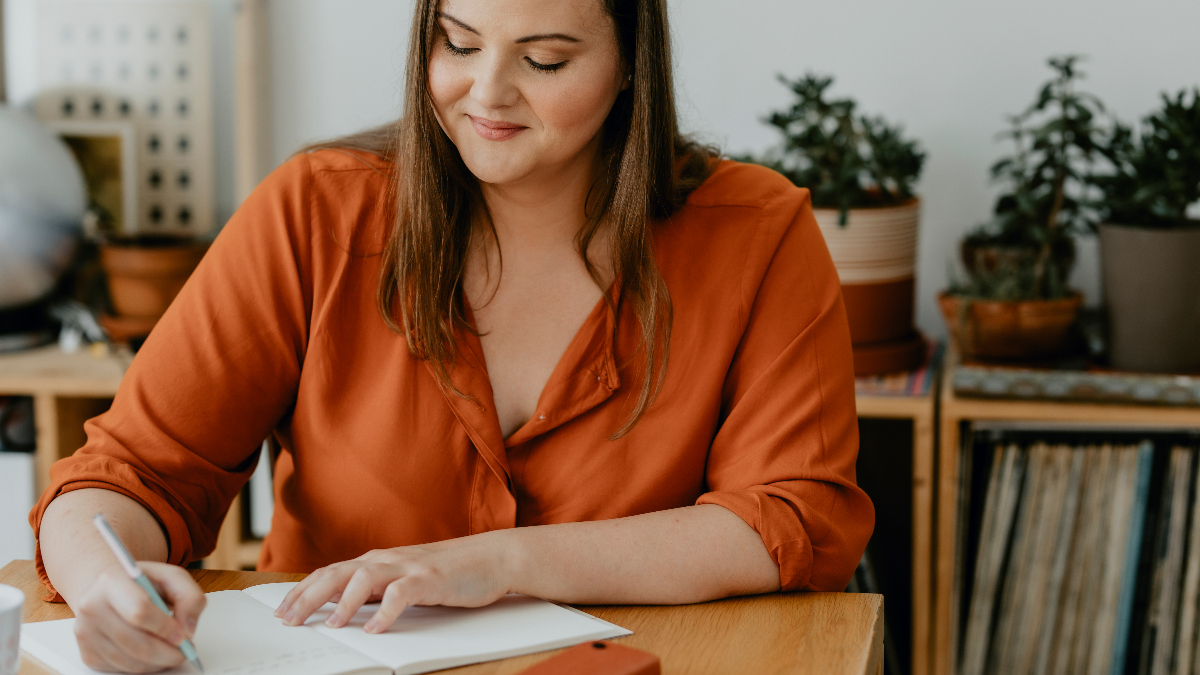 Young woman happily journals about what brings her hope, as she endeavors to answer the question, how do I find hope?