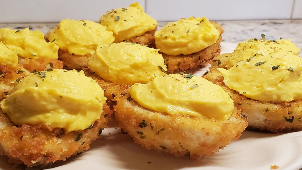 A batch of fried deviled eggs on a plate