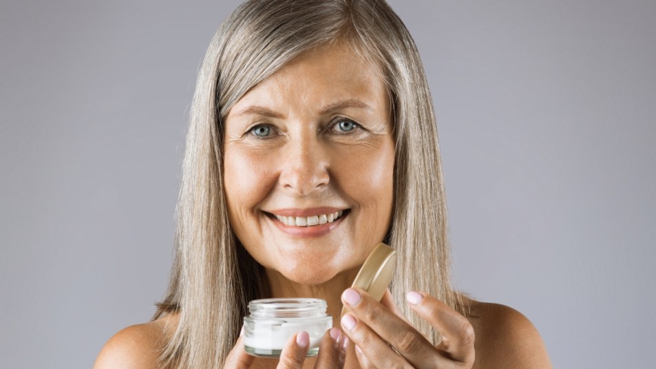 Mature woman holding moisturizer