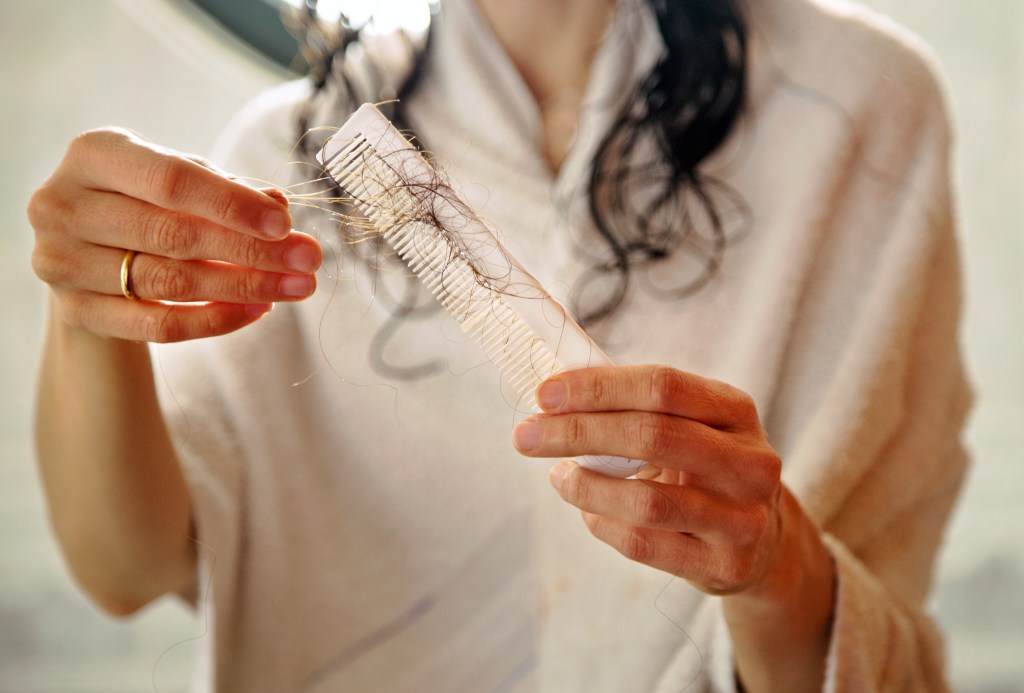 woman losing hair in comb