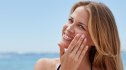 Woman applying a mineral or chemical sunscreen to her face