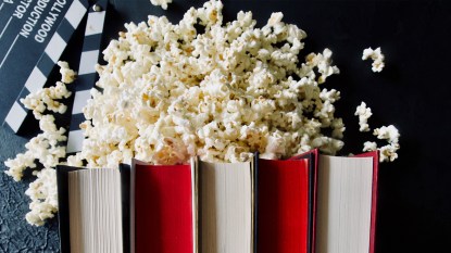 stack of books with popcorn and movie clapper; christian movies based on books