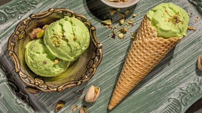 Scoops of pistachio ice cream served in a bowl and a waffle cone