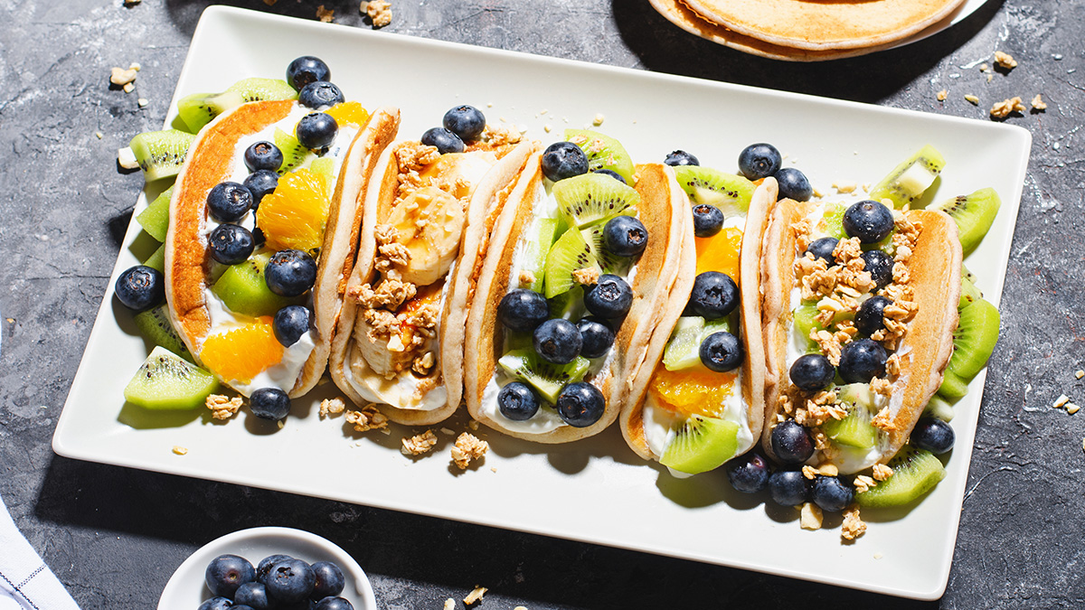 Sweet fruit-filled pancake tacos on a platter