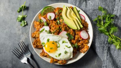 chilaquiles with avocado and fried egg on plate