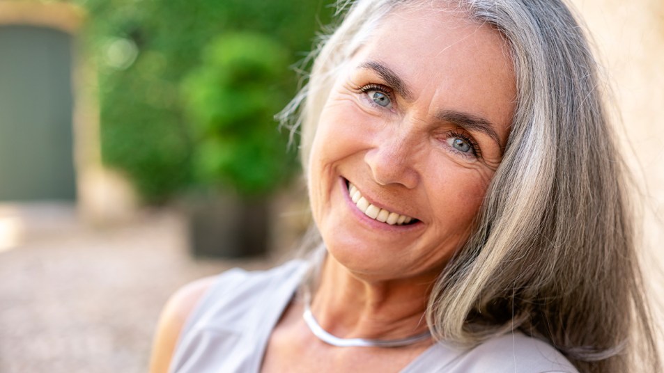 Woman outside with radiant skin after doing summer skin care