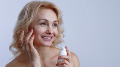 Woman applying one of the best sunscreens like supergoop unseen sunscreen