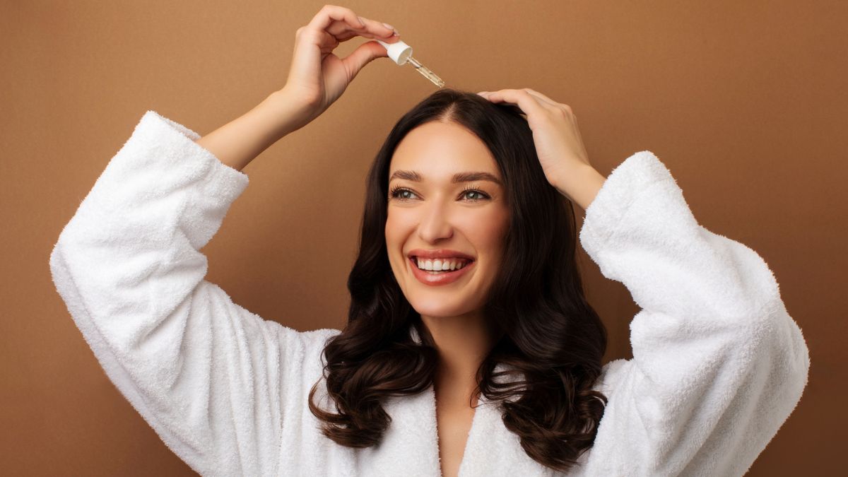 A woman applying a PDRN scalp serum to boost hair growth