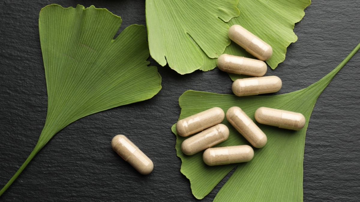Ginkgo biloba leaves with supplements on top