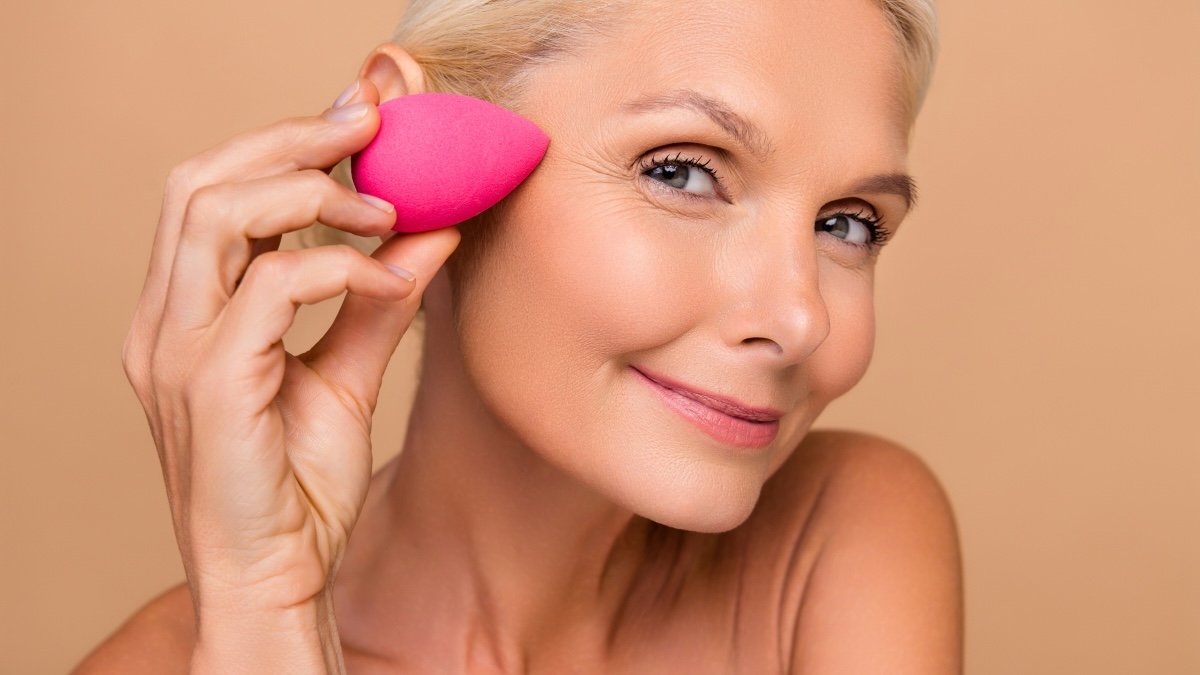A woman using a makeup sponge to help get rid of puffy eyes