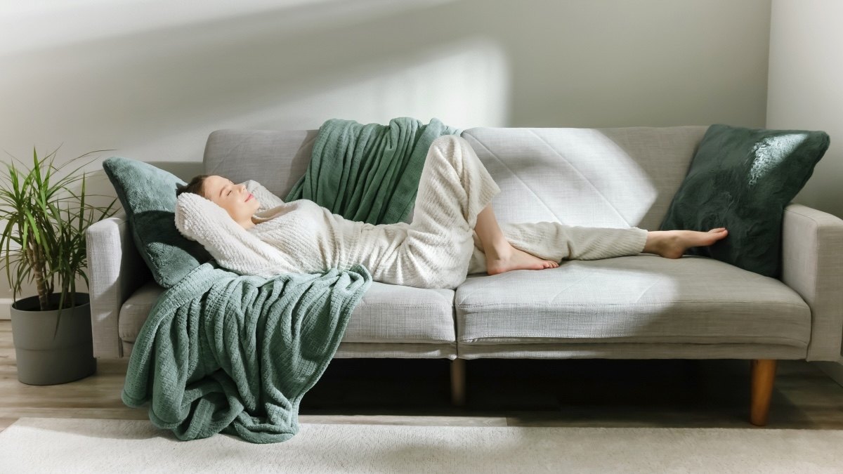 A woman sleeping soundly on her couch after using the Oura Ring 5